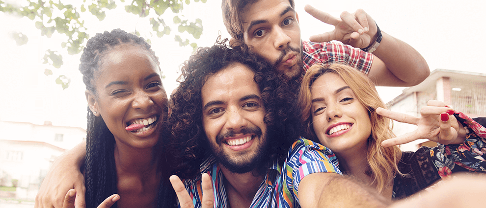 Relacionamento saudável: grupo de amigos, com dois homens e duas mulheres, reunidos e sorridentes para uma selfie.