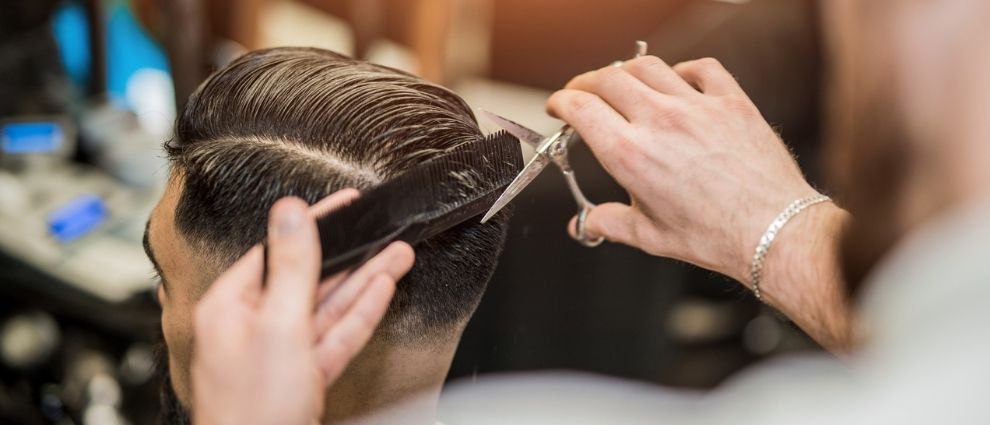 Homem na barbearia aderindo ao risco no cabelo.